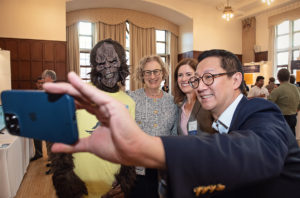 Photo of U-M President Santa Ono taking a selfie with VPR Cunningham, AVP Sexton and the Monstr Sense Bigfoot mascot.